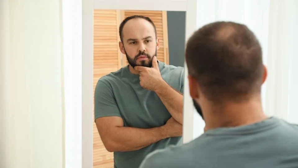 how to cut back on alcohol? a man looks into a mirror to figure it out