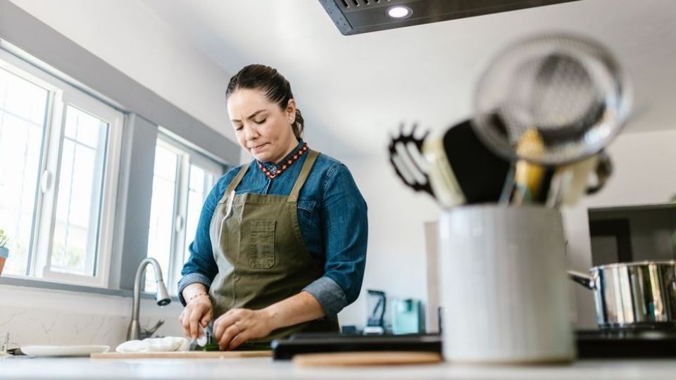 Woman cooking a simple meal, one habit that helps support brain recovery from alcohol.